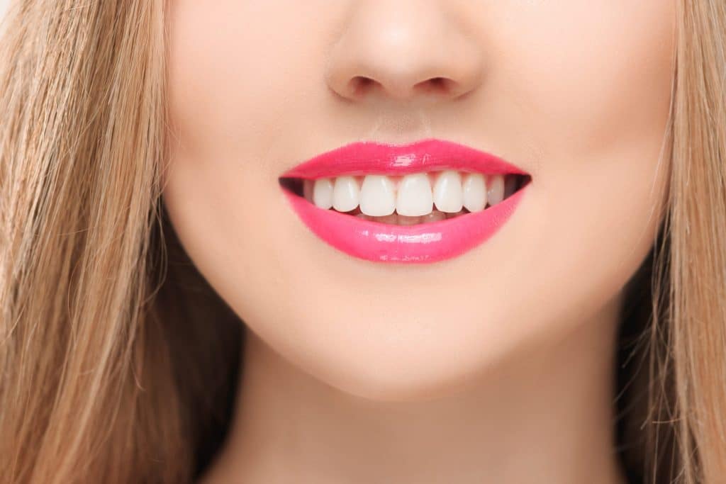 Close-up of lips and white teeth, mouth open