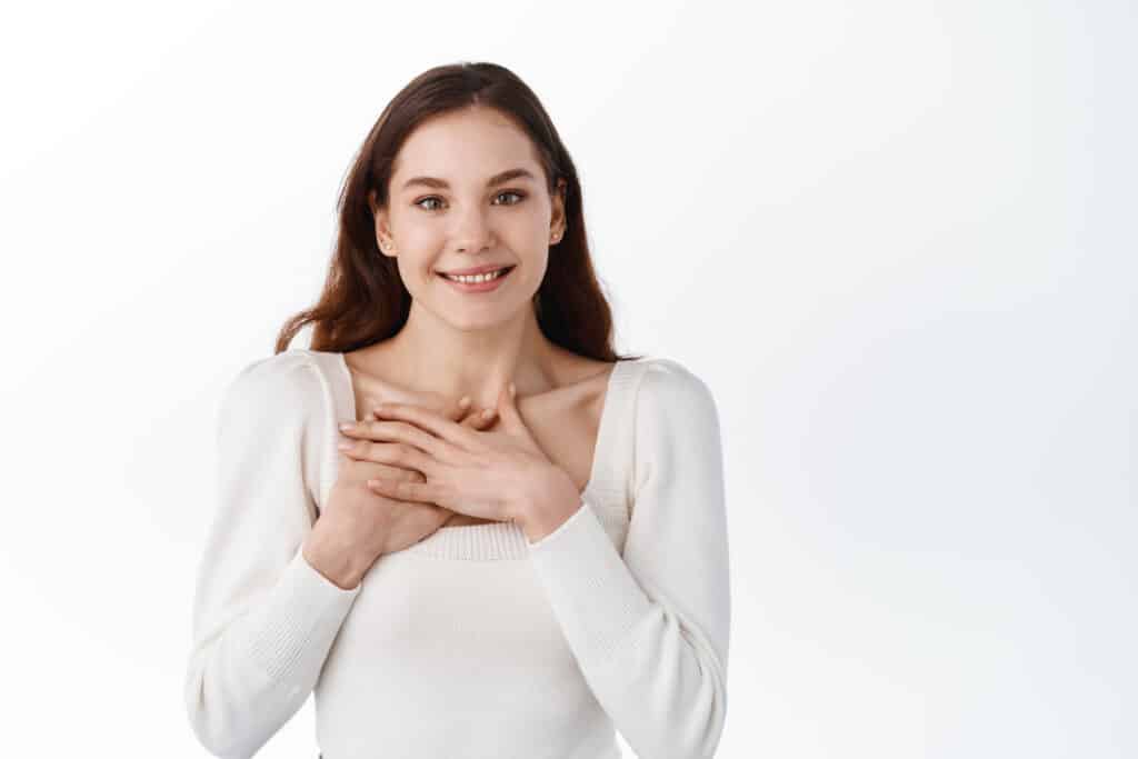 Young woman with hands over heart, grateful 2