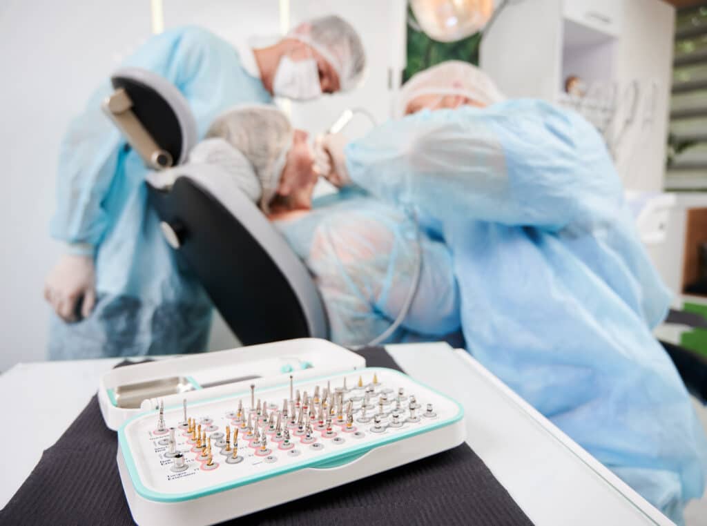 Dentist and assistant treating patient in dental chair