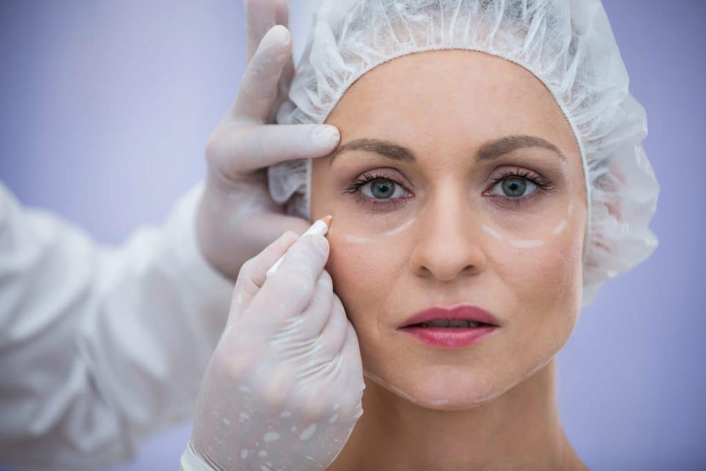Doctor marking patient's face for cosmetic treatment 2